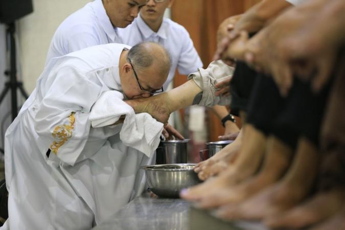 A Catholic priest kisses the foot of a devotee on Holy Thursday in Philippines Maundy Thursday