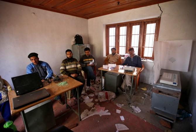 In picture: Polling officials sit as they wait for voters to turn up at an empty polling station during a re-polling in the Srinagar parliamentary constituency in Wathora on the outskirts of Srinagar in Jammu and Kashmir on April 13, 2017. Srinagar bypolls