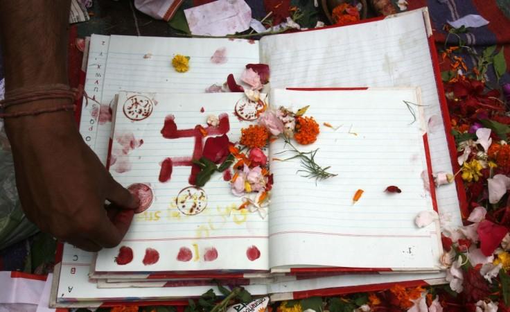 A Hindu priest blesses the financial ledger book of a trader during a ritual on the first day of the Bengali New Year in front of a temple in Kolkata. Bengali New Year
