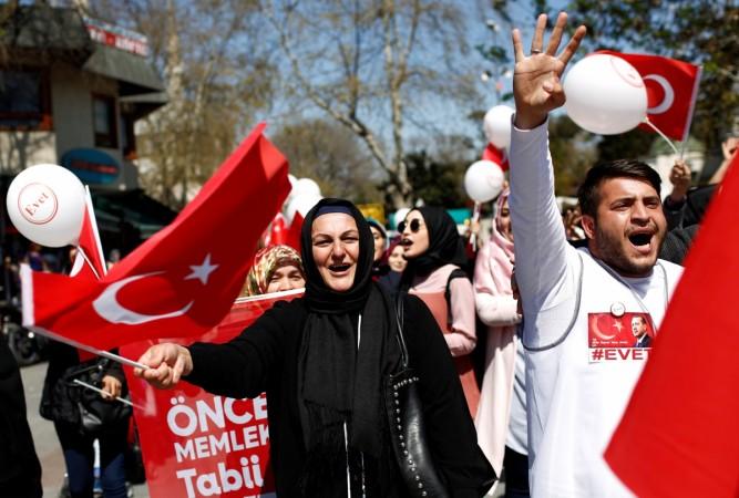 Supporters of Turkish President Tayyip Erdogan wave Turkey's national flags and Turkey referendum