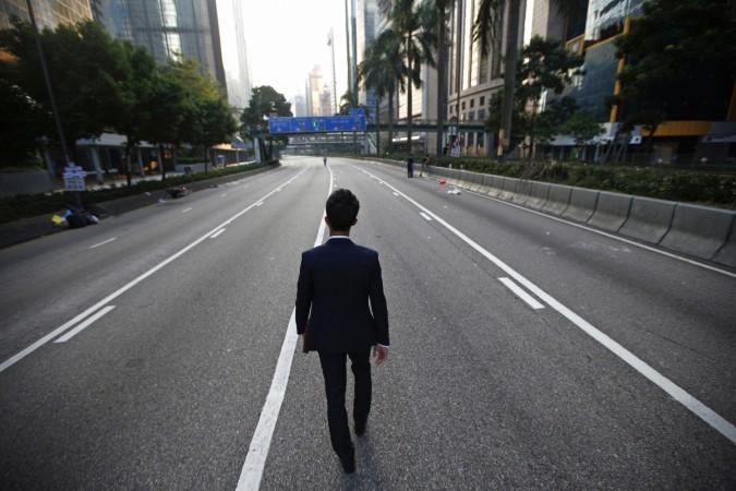A man walks along an empty street near the central financial district in Hong Kong Suit