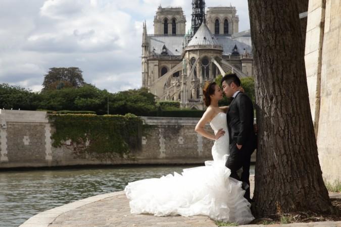 A Chinese couple poses during a pre-wedding photoshoot in front of the Notre-Dame Cathedral in Paris Destination wedding