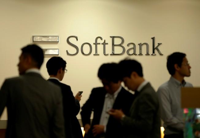 Men are seen in front of the logo of SoftBank Group Corp at the company's headquarters in Tokyo, June 30, 2016. One97 communications, paytm, paytm to invest rs 12,000 crore, Softbank to invest in paytm, paytm digial wallet company, fintech companies in india, paytm investors