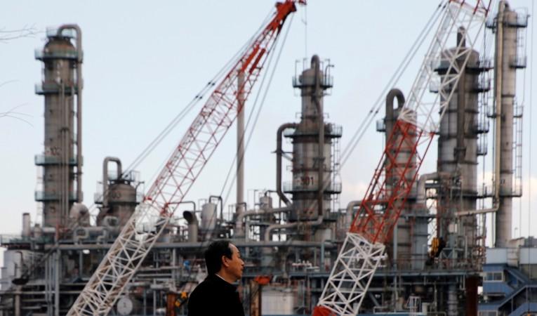 A worker walks near a factory at the Keihin industrial zone in Kawasaki, Japan, March 8, 2017. asia pmi april 2017, japan pmi, india pmi, china pmi, asian factories in full swing in april 2017, global economic recovery