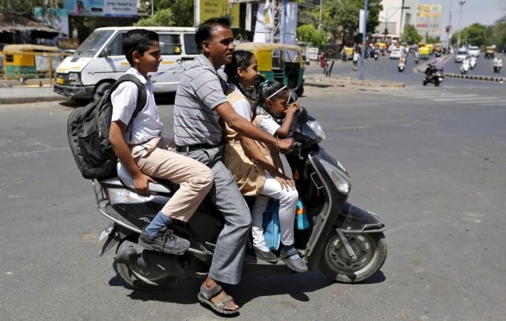 A man rides a scooter and ferries students to their school Students