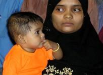 Bilkis Yakub Rasool, holds her six-month-old daughter Fatima, during a news conference in the western Indian city of Ahmedabad, August 8, 2004.