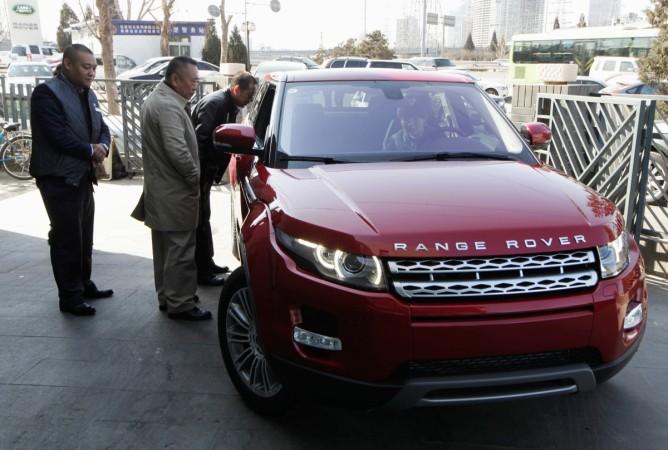 Customers look at a Range Rover Evoque car outside a dealership in Beijing, China, February 17, 2012. jlr car sales april 2017, jlr april 2017 sales, jaguar car sales, land rover car sales, tata motors share price, sensex losers