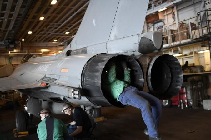 Flight engineers inspect a Rafale fighter jet aboard the Charles-de-Gaulle aircraft carrier operating in the eastern Mediterranean Sea on December 9, 2016. french elections 2017, french polls 2017, Élysée palace, centrist emmanuel macron, far right marine le pen, french economy, india france bilateral trade, paris fashion, fashion shows in paris