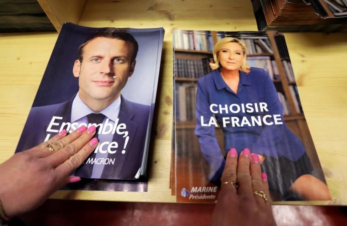 Civil servants prepare electoral documents for the upcoming second round of 2017 French presidential election with envelops of Emmanuel Macron (left) and Marine Le Pen (right) Macron and Le Pen