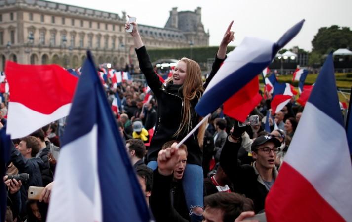 Supporters of Emmanuel Macron celebrate near the Louvre museum, France May 7, 2017. french elections 2017, french polls 2017, Élysée palace, centrist emmanuel macron, far right marine le pen, french economy, india france bilateral trade, paris fashion, fashion shows in paris