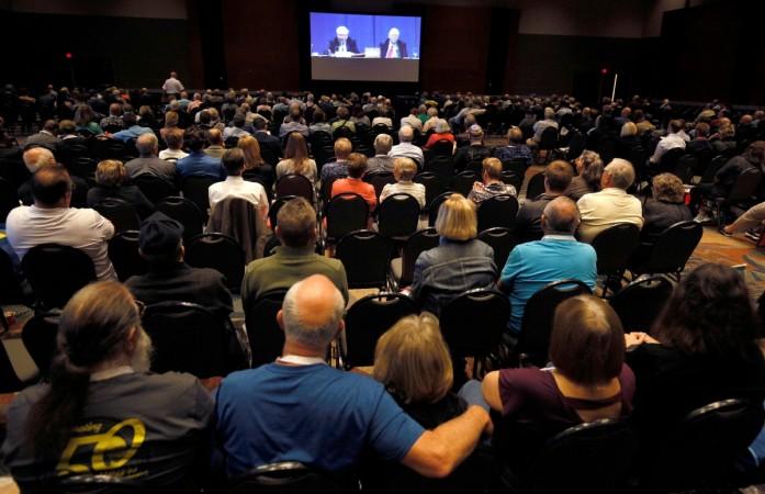 Berkshire Hathaway shareholders in an overflow room watch the Berkshire Hathaway annual meeting on a TV screen in Omaha, Nebraska, U.S. May 6, 2017. Warren Buffett, Berkshire Hathaway, american companies, billionaires, forbes list, rich persons, us stock markets, wealth creators, wealthy individuals