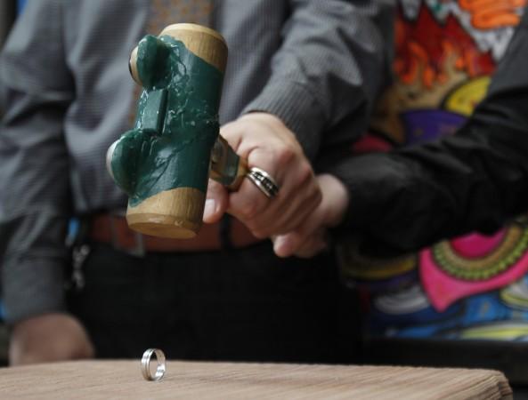 A couple uses a hammer to smash their wedding ring to symbolise the end of their eight-year marriage Divorce