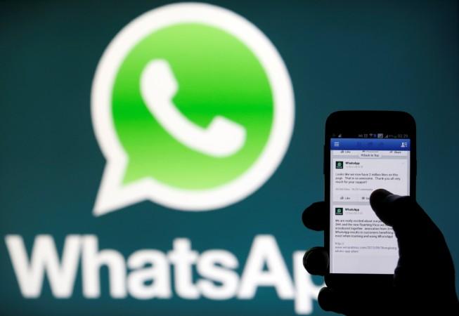 A WhatsApp logo is seen behind a phone