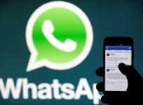 A WhatsApp logo is seen behind a phone