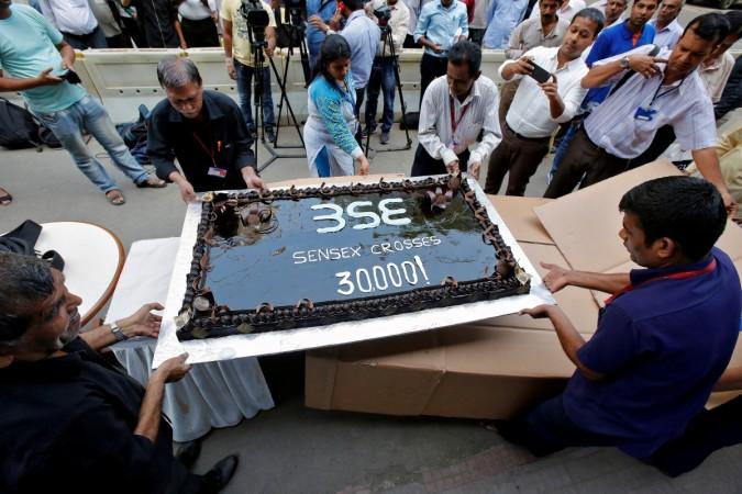 Employees of the Bombay Stock Exchange (BSE) carry a cake outside the building for the celebrations marking the Sensex index rising over 30,000, in Mumbai, April 26, 2017. sensex at new high, nifty at new high, stocks at fresh 52 week high, stocks nearing alltime high, sensex gainers