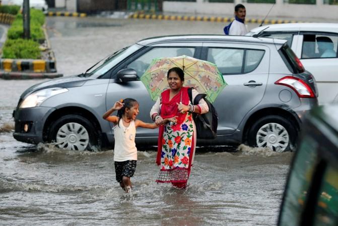 A woman and girl wade across a flooded road during monsoon rains in New Delhi, India August 31, 2016. monsoon, rainfall, rain, imd, monsoon prediction, rainfall prediction, agriculture, farming, sensex, stock markets