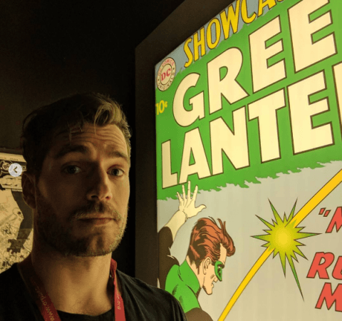 Henry Cavill with a cover poster of Green Lantern comic. Superman