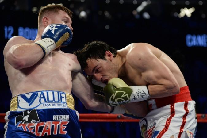 Canelo Alvarez (blue/gold trunks) lands a cross punch on Julio Cesar Chavez Jr. canelo chavez, boxing