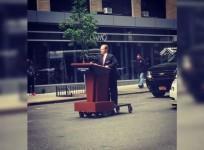 Melissa McCarthy cruises through NY as Sean Spicer on motorised podium