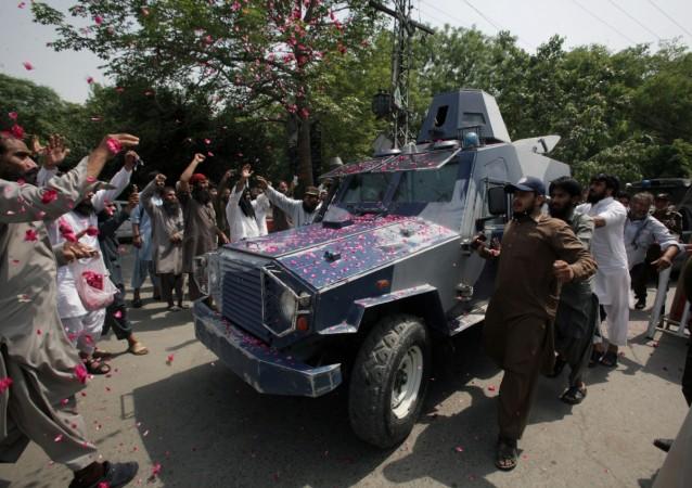 Supporters of Hafiz Saeed shower rose petals on Armoured Personal Vehicle carrying Saeed, after he appeared before a court to challenge his house arrest in Lahore, Pakistan, May 13, 2017. Hafiz Saeed