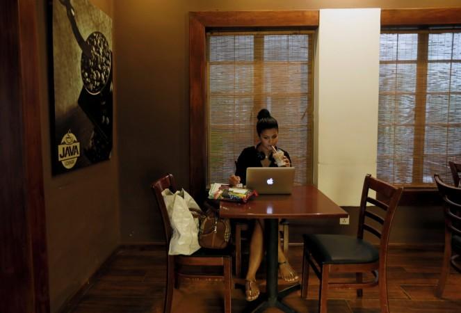 A woman drinks her coffee, while working on her laptop, at Java Lounge coffee shop in Colombo, Sri Lanka Video interview