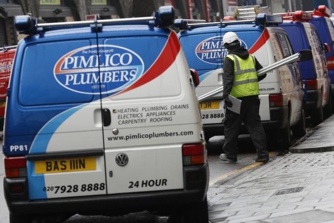 A worker walks past a Pimlico Plumbers van in London, Britain February 10, 2017. britain, british unemployment rate, unemployment rate in britain, brexit and unemployment