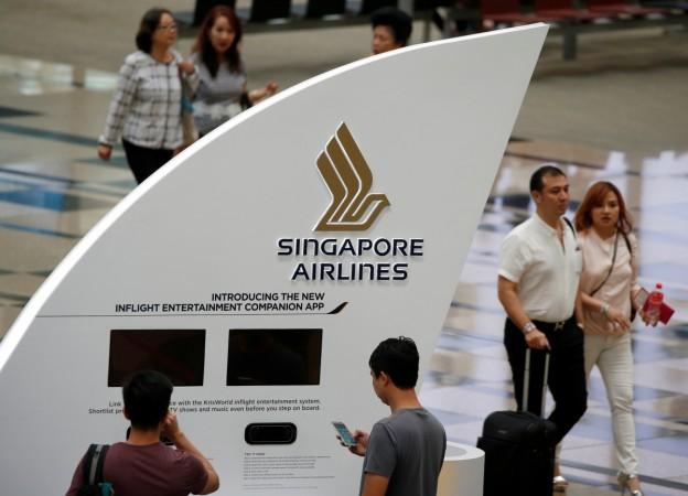 People pass a Singapore Airlines signage at Changi Airport in Singapore May 11, 2016. cathay pacific, job cuts at cathay pacific, global aviation in turmoil, singapore airlines weak results, radical changes in singapore airlines