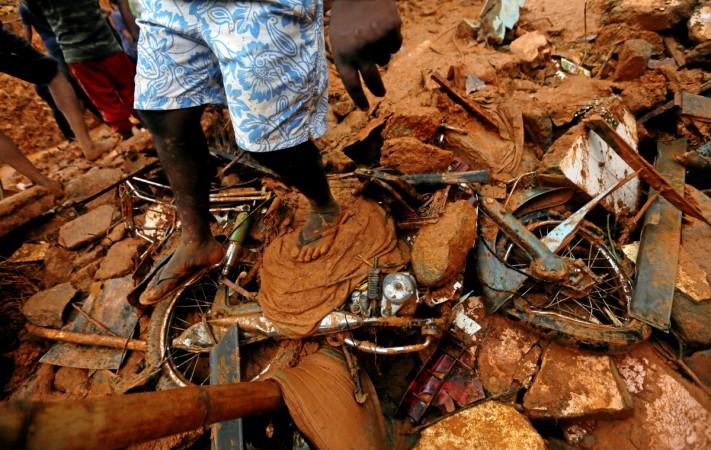 A man stands on top of a damaged bike during a rescue mission at the site of a landslide in Bellana village in Kalutara, Sri Lanka, May 26, 2017. Sri Lanka landslide