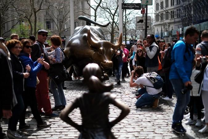Fearless Girl stares up at the Charging Bull at Wall Street. Fearless Girl