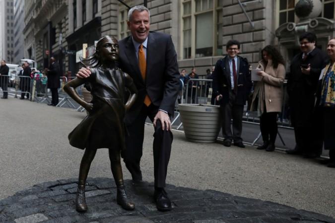 New York City Mayor Bill de Blasio poses next to the Fearless Girl