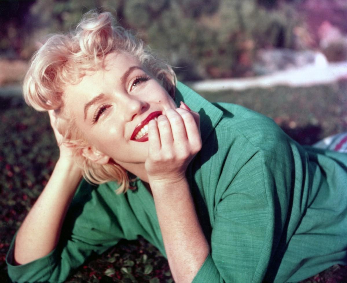 Actress Marilyn Monroe poses for a portrait laying on the grass in 1954 in Palm Springs, California. Marilyn Monroe