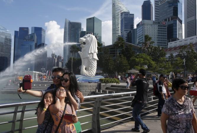 Tourists take photos by the famous Merlion fountain in Singapore July 29 2015. singapore, threat to singapore, terror attacks, terror groups in southeast asia, terror attack in kabul, singapore tourism
