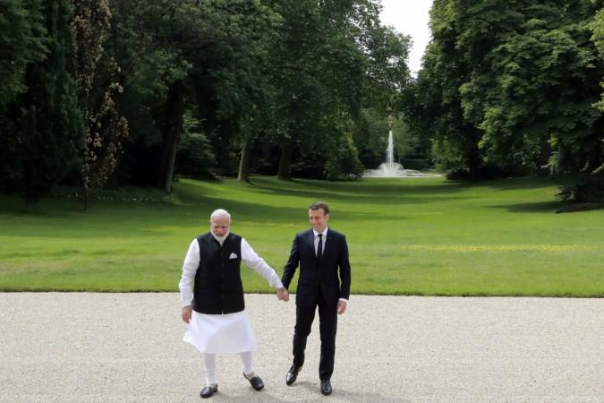 Indian Prime Minister Narendra Modi (L) and French President Emmanuel Macron (R) hold hands as they talk in the garden of the Elysee Palace following their meeting in Paris, France, June 3, 2017. Modi Macron