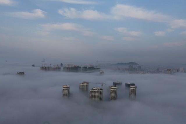 Buildings and construction sites are seen submerged in fog in China. World Environment Day, nature shocking photos
