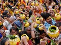 Hindu devotees carry earthen pots filled with sacred water to offer to the Hindu god of destruction, Lord Shiva, during a religious festival of Nirjala Ekadashi in the northern Indian city of Varanasi