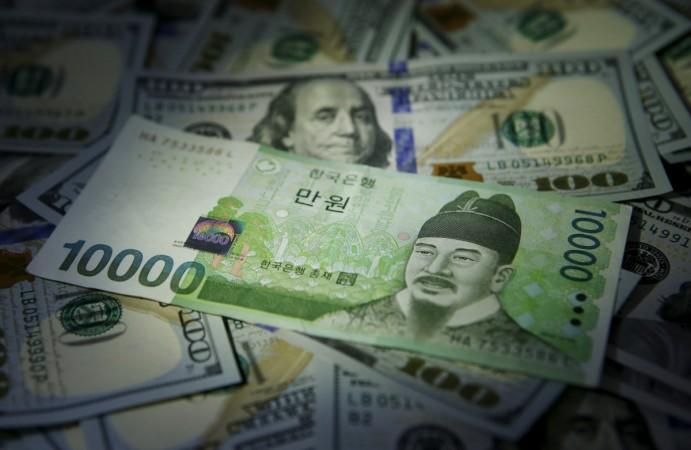 South Korean 10,000 won note is seen on U.S. 100 dollar notes in this picture illustration taken in Seoul, South Korea, December 15, 2015. india korea bilateral trade, india $9 billion credit to korea, india korea exports, india korea trade talks
