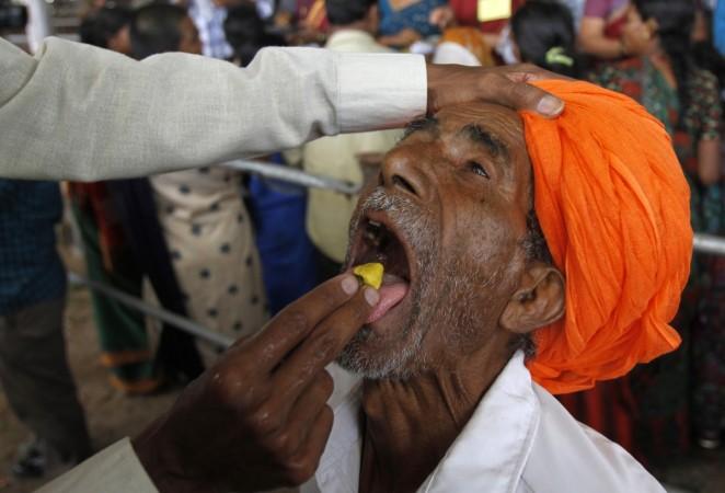 A man prepares to swallow a live fish that has been dipped in homemade medicine in Hyderabad.. Asthma