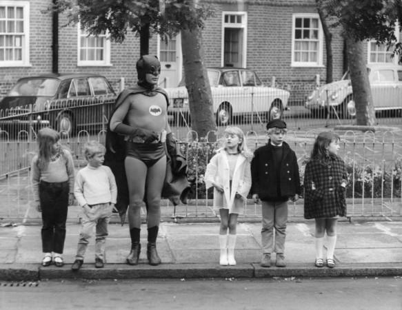 American actor Adam West, as Batman, making a road safety film with a group of child actors in Kensington, London. Adam West as Batman