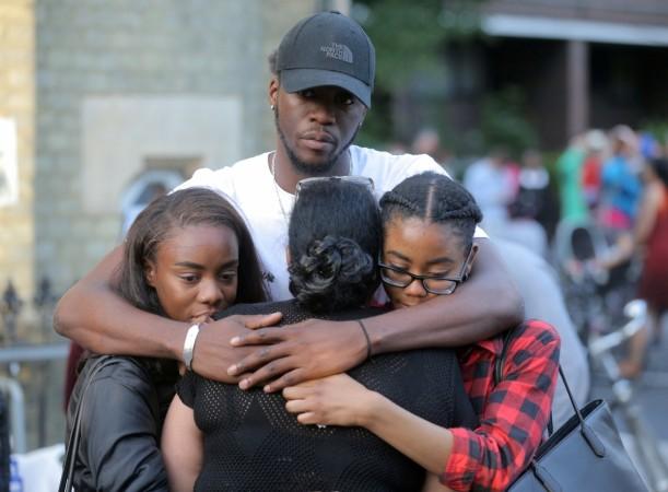 In picture: People comfort each other after a prayer vigil outside Notting Hill Methodist Church close to the tower block severely damaged by a serious fire, in north Kensington, West London, Britain June 15, 2017. London fire
