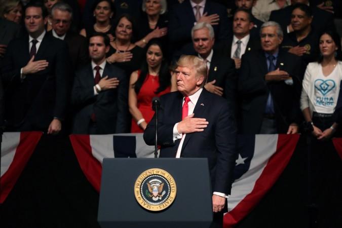 U.S. President Donald Trump watches as Cuban violinist Luis Haza (not seen) plays the National Anthem as Trump announces policy changes toward Cuba at the Manuel Artime Theater in the Little Havana neighborhood on June 16, 2017 in Miami, Florida. donald trump, trump cuba policy, obama cuba policy, trump administration, trumponomics, cuba us relations