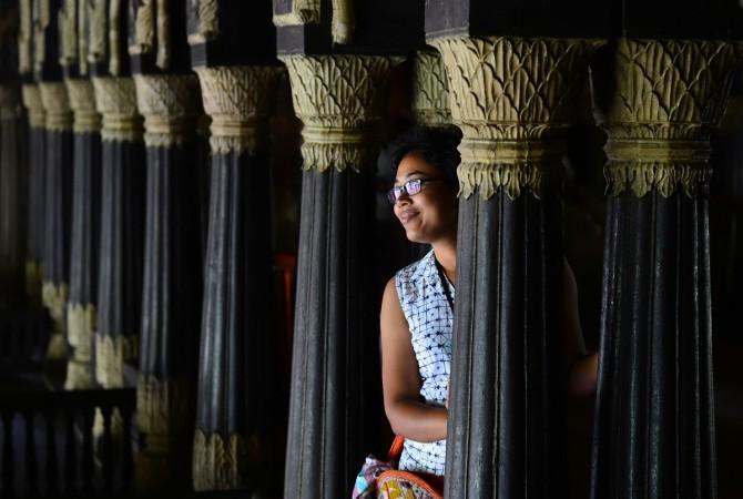 An Indian tourist gets her picture taken next to pillars at Tipu Sultan's Summer Palace in Bengaluru on June 17, 2017. invest japan seminar, bcic jetro event, japan tourists in karnataka, karnataka govt, Consul General of Japan Takayuki Kitagawa