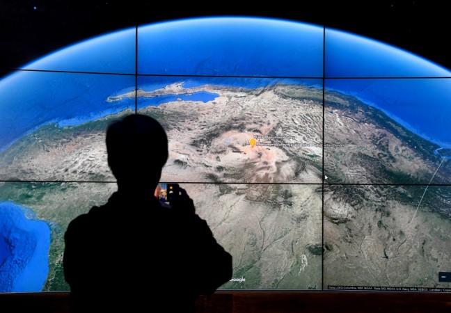 A man looks at a Google Earth map on a screen as Google Earth unveils the revamped version of the application April 18, 2017 at a event at New York's Whitney Museum of Art. Google Maps