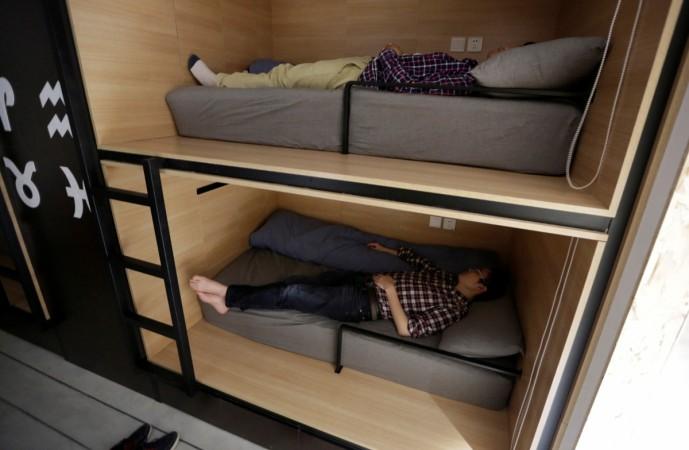 Wu Binbin (bottom) and Chen Huiyang, employees at BaishanCloud, take a nap after lunch in individual sleeping quarters, in the office, in Beijing. Napping at work