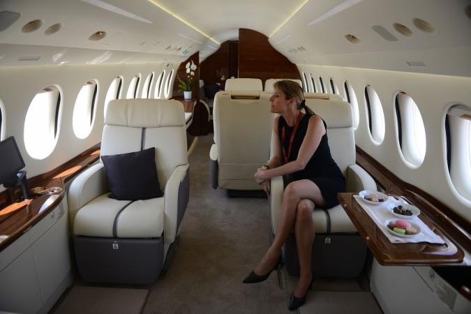 A member of Dassault Aviation staff sits inside a cabin of a Falcon 2000 LX Business Jet parked at a static display at the India Aviation 2014 airshow at Begumpet Airport in Hyderabad on March 13, 2014. Falcon 2000 LX Business Jet