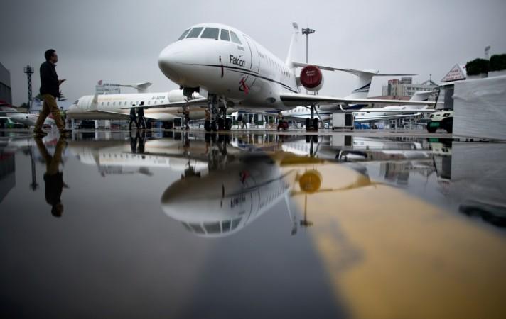 A man passes the Dassault Falcon 2000EX business jet before the start of the 2017 Asian Business Aviation Conference and Exhibition (ABACE) at Shanghai's Hongqiao Airport on April 10, 2017 Dassault Falcon 2000EX