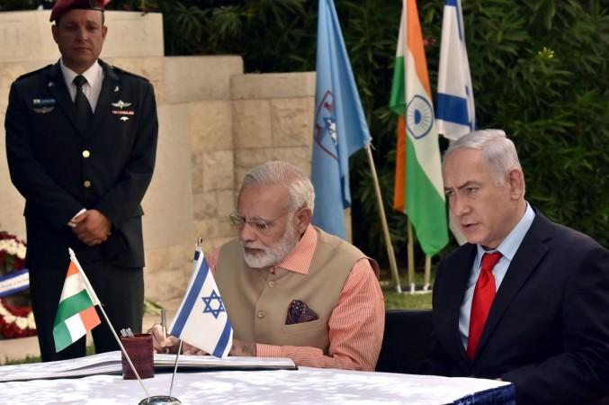 Prime Minister Narendra Modi signing the Visitors' Book at the Indian cemetery at Haifa, which Indian cavalry regiments helped liberate in 1918, in Israel on July 6, 2017. The Prime Minister of Israel, Benjamin Netanyahu, is also seen. Modi in Haifa