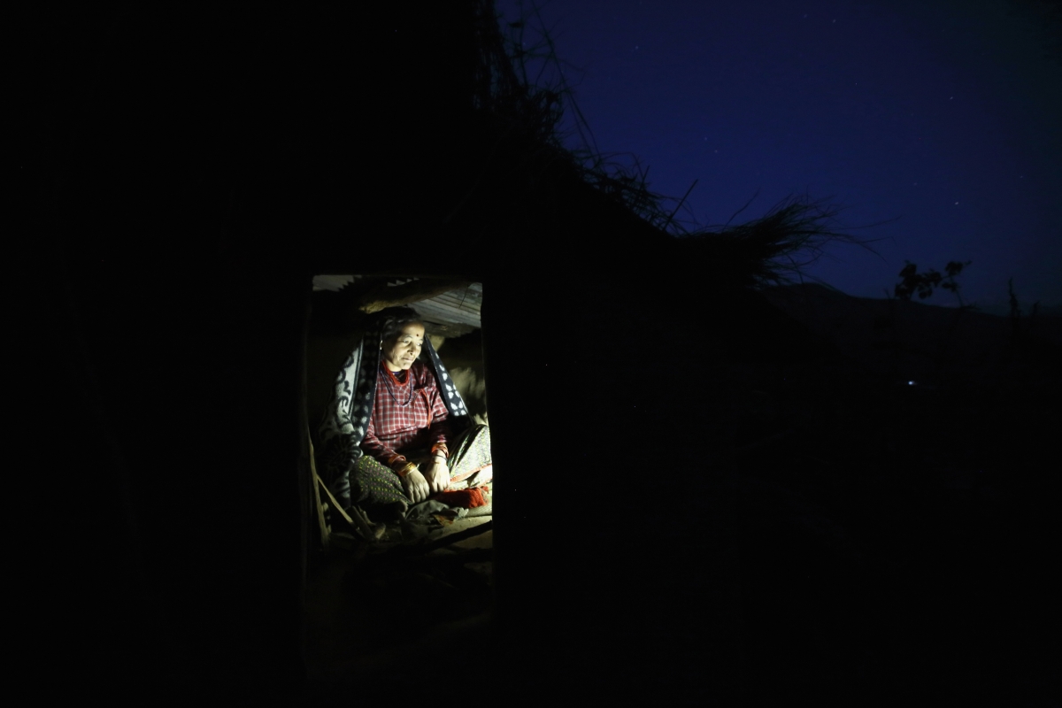 Dhuna Devi Saud prepares to sleep inside a Chaupadi shed in the hills of Legudsen village in Achham District in western Nepal February 16, 2014. Chaupadi