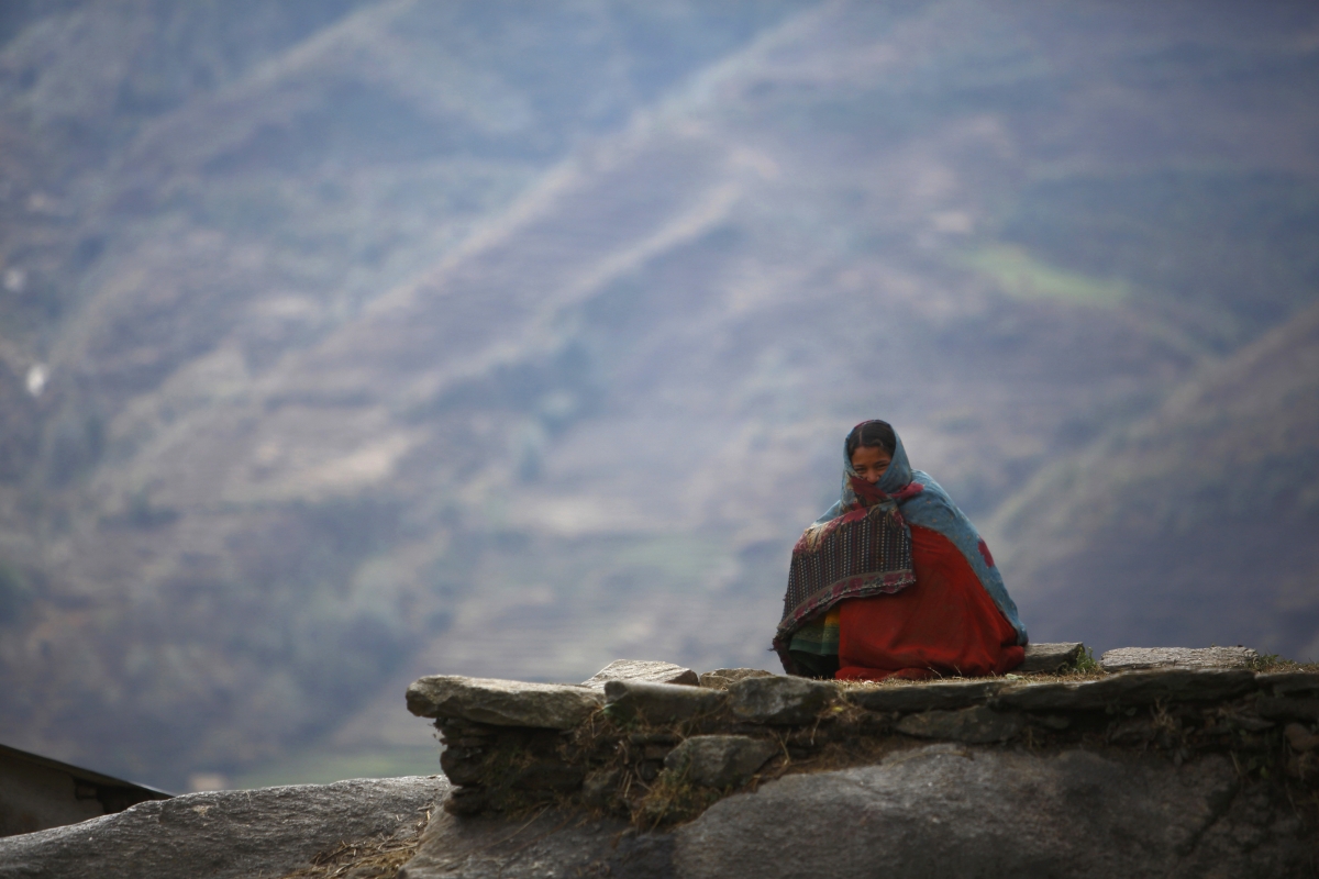 Surja Devi Saud, 20, who practices Chaupadi, sits outside her house in Achham District in western Nepal February 16, 2014. chaupadi