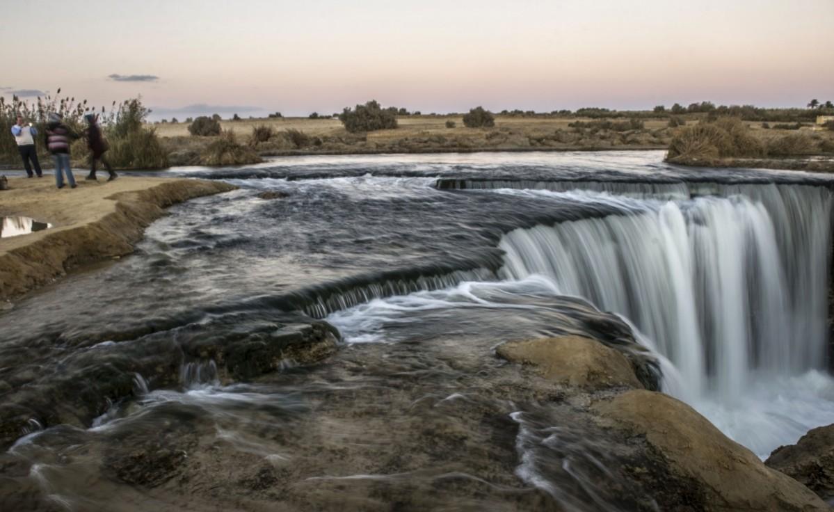 Egyptian visitors taking pictures on the banks of a waterfall in Wadi al-Rayan, south-west of the capital Cairo in the Fayyum Governorate, on January 14, 2016. Faiyum