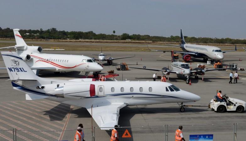 Indian groundstaff move a Cessna N79XL aircraft to be parked on display at Begumpet Airport in Hyderabad on March 11, 2014 gmr group, hyderabad airport, gmr to sell stake to abu dhabi investment authority, gmr stake sale hyderabad airport